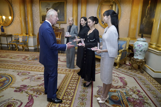 Britain's King Charles III, left. presents the members of the K-Pop band Blackpink with MBEs, Member of the Order of the British Empire at Buckingham Palace, in London, Wednesday, Nov. 22, 2023. [YONHAP]