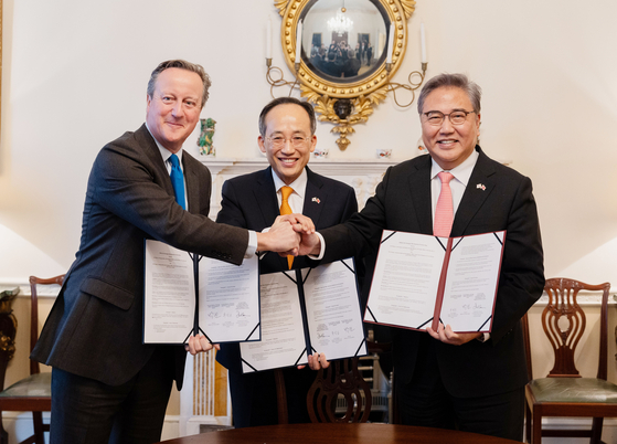 Finance Minister Choo Kyung-ho, center, Foreign Minister Park Jin, right, and British Foreign Secretary David Cameron pose for a photo during a signing ceremony of the Strategic Development Partnership in London. [NEWS1]