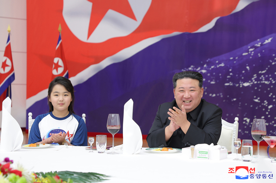 In this photo released by Pyongyang's state-controlled Korean Central News Agency on Friday, North Korean leader Kim Jong-un, right, is seen seated next to his daughter Kim Ju-ae at a banquet held the previous night to celebrate the North's launch of a spy satellite earlier in the week. [YONHAP]