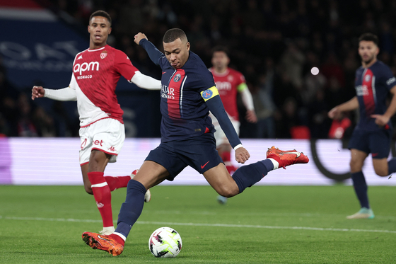 Paris Saint-Germain forward Kylian Mbappe, center, shoots toward the goal during the French L1 football match between PSG and AS Monaco in Paris on Friday. [AFP/YONHAP]