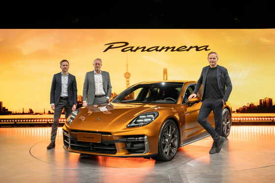 From left, Peter Varga, director of exterior design at Porsche, Detlev von Platen, member of the executive board for sales and marketing, and Oliver Blume, chairman of the executive board pose with the latest Panamera Turbo E-Hybrid at an unveiling event in Shanghai, China, on Friday. [PORSCHE KOREA]