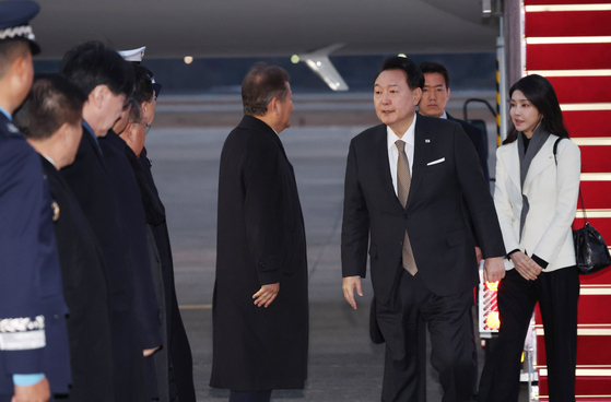 President Yoon Suk Yeol, second from right, and first lady Kim Keon Hee, right, greet officials after their return from a weeklong trip to Britain and France at Seoul Air Base in Seongnam, Gyeonggi, on Sunday. [JOINT PRESS CORPS]