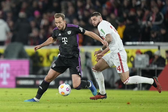 Bayern's Harry Kane, left, challenges for the ball with Cologne's Julian Chabot during the German Bundesliga soccer match between 1.FC Cologne and Bayern Munich in Cologne, Germany on Friday. [AP/YONHAP]