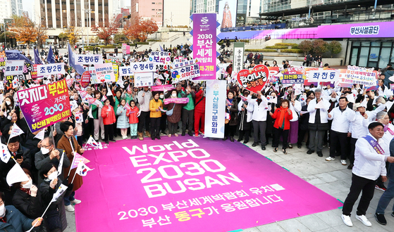  Busan residents on Monday cheer and show support for the city's bid to host World Expo 2030 near Busan Station. [SONG BONG-GEUN]