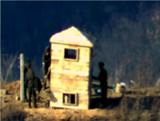 North Korean soldiers rebuild a wooden guard post inside the demilitarized zone on Friday. [MINISTRY OF NATIONAL DEFENSE]