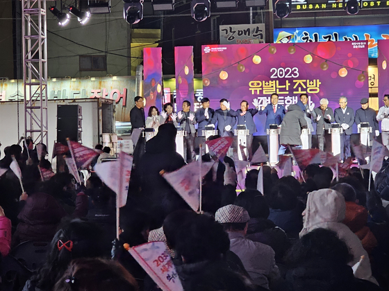 A lighting ceremony for winter season street decorations is held in Dong District, Busan, with its mayor Kim Jin-hong on stage, ahead of the final decision for the hosting city of the 2030 World Expo to be decided. Dong District residents who attended the event wave flags supporting Busan's bid. [SHIN HA-NEE]
