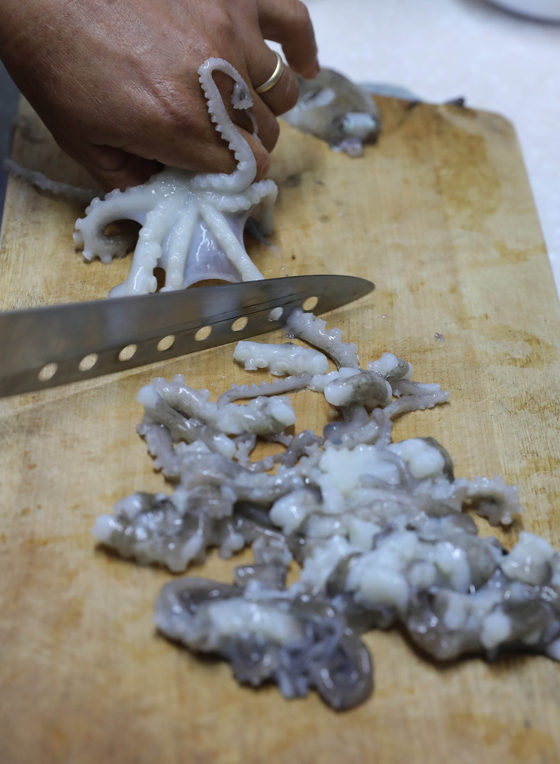 A cook prepares nakji tangtangi, which is seasoned pieces of small, moving nakji tentacles. [JOONGANG PHOTOS]