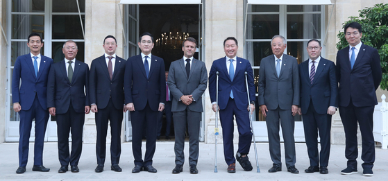 Chiefs of Korea's eight conglomerates pose with French President Emmanuel Macron, center, at the Elysee Palace in Paris in June when the business leaders were in the city to participate the general assembly of the Bureau International des Expositions to promote Busan as the host of the World Expo 2030. From left: Hanwha Group Vice Chairman Kim Dong-kwan, Hyundai Motor Group Executive Chair Euisun Chung, LG Chairman Koo Kwang-mo, Samsung Electronics Executive Chairman Lee Jae-yong, French President Emmanuel Macron, SK Group Chairman Chey Tae-won, Poongsan Group and Federation of Korean Industries Chairman Ryu Jin, Hyosung Group Vice Chairman Cho Hyun-sang and Hanjin Group Chairman Walter Cho. [KOREA CHAMBER OF COMMERCE AND INDUSTRY]