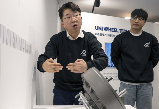 Park Jong-sool, left, a senior fellow at Hyundai Motor Group’s Institute of Advanced Technology Development, speaks to the press on Tuesday in central Seoul. Hyundai Motor introduced the Universal Wheel Drive System, dubbed UNI Wheel, in a press conference that day. [HYUNDAI MOTOR]