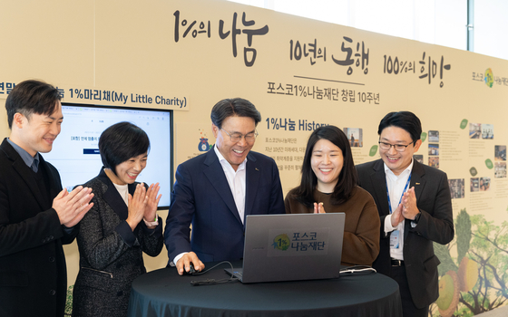 Posco Group Chairman Choi Jeong-woo, center, makes this year's first donation for the Posco 1% Foundation's 1% My Little Charity campaign on Nov. 8, during the foundation's 10-year anniversary ceremony held at Posco Center in southern Seoul. [POSCO HOLDINGS]