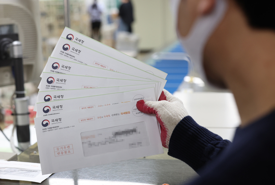 A worker at Gangnam Post Office in southern Seoul sorts out bills for the comprehensive real estate holding tax on Wednesday. [YONHAP]