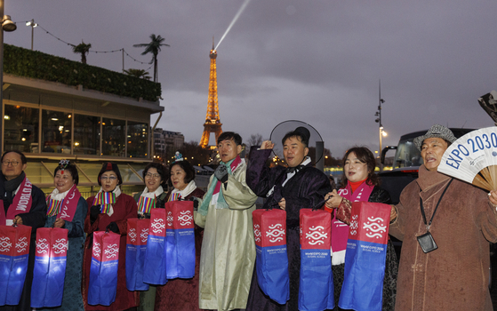 Members of a civic group hold lanterns promoting Busan’s World Expo 2030 bid near the Seine River in Paris on Monday, on the eve of the final vote determining the host city by the France-headquartered Bureau International des Expositions (BIE). [YONHAP]
