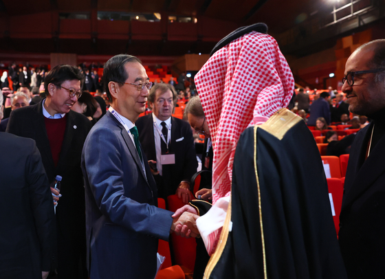 Korean Prime Minister Han Duck-soo, left, shakes hands with a Saudi official after the fifth and final presentation for Busan’s bid to host the 2030 World Expo at the 173rd general assembly of the Bureau International des Expositions (BIE) at the Palais des Congres in Paris on Tuesday. The presentation came ahead of the BIE secret ballot, through which Saudi Arabia's Riyadh was chosen to host the 2030 World Expo, beating out the Korean port city Busan and Italy’s Rome. [YONHAP]