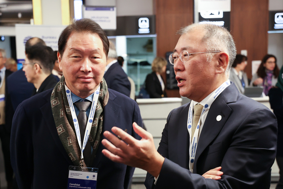 SK Group Chairman Chey Tae-won, left, and Hyundai Motor Group Executive Chair Euisun Chung speak at the 173rd general assembly of the Bureau International des Expositions in France on Tuesday evening. [YONHAP]