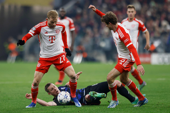 Bayern Munich's Konrad Laimer, left, and Thomas Mueller vie for the vall with FC Copenhagen's Lukas Lerager during a Champions League match in Munich, Germany on Wednesday. [AFP/YONHAP]  