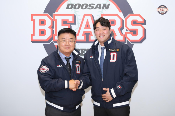 Doosan Bears' Yang Suk-hwan, right, takes a photo with general manager Kim Tae-ryong after signing a contract to remain with the team at the Doosan Bears' office at Jamsil Baseball Stadium in southern Seoul on Thursay. [DOOSAN BEARS]