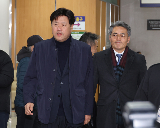 Kim Yong, a former deputy head of the Democratic Party-affiliated think tank Institute for Democracy, left, attends a court ruling on Thursday at the Seoul Central District Court in Seocho District, southern Seoul. [YONHAP]