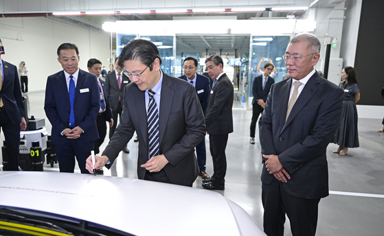 Singapore's Deputy Prime Minister, Lawrence Wong, autographs an Ioniq 5-based self-driving Robotaxi at an event celebrating Hyundai Motor's completion of a plant in Singapore. [HYUNDAI MOTOR]