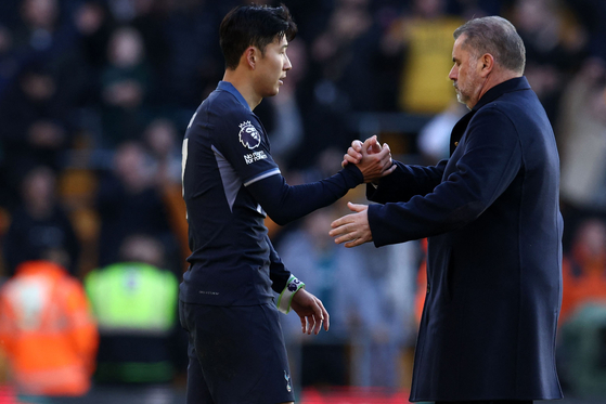 Tottenham Hotspur manager Ange Postecoglou, right, shakes hands with Spurs striker Son Heung-Min on the pitch after the match against Wolverhampton Wanderers in Wolverhampton, central England on Nov.11. [AFP/YONHAP]
