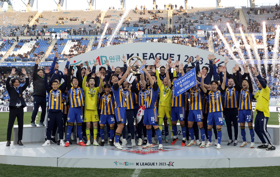 Ulsan Hyundai players celebrate winning the 2023 K League 1 title and raise the league trophy at Ulsan Munsu Football Stadium in Ulsan on Sunday. [NEWS1] 
