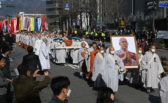 Monks march in a funeral procession for Ven. Jaseung, a former head of the Jogye Order of Korean Buddhism, in Jongno District, central Seoul, on Sunday. [NEWS1]