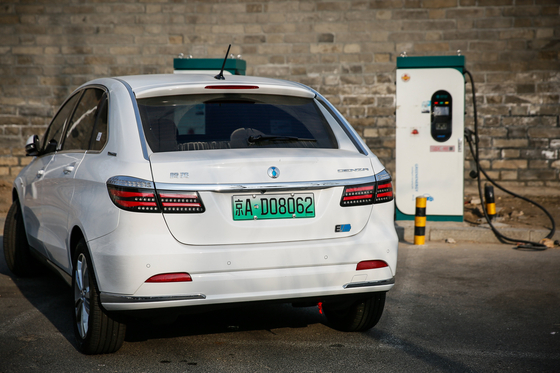 An electric car with an exclusive license plate is charged at an electric vehicle charging station in Beijing, China. [EPA/YONHAP]
