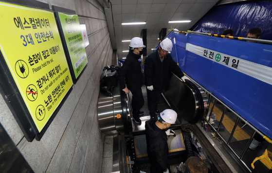 Korea Elevator Safety Agency officials on Tuesday disassemble the escalator that malfunctioned and injured 10 people on Monday during the morning rush hour at Gyeongbokgung Station in central Seoul. Two of the injured were taken to hospital. [YONHAP]