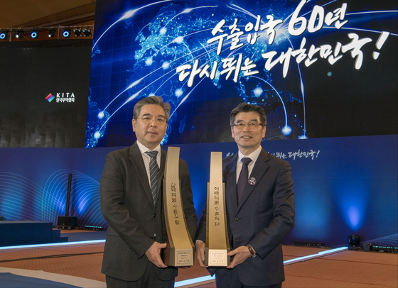 Hyundai Motor CEO Chang Jae-hoon, left, and Kia CEO Song Ho-sung pose for the photo with their Export Tower awards given by the Korea International Trade Association in Coex in southern Seoul on Tuesday. [HYUNDAI MOTOR]