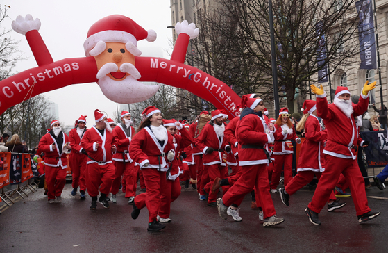 Runners dressed as Santa Claus take part in the annual 5-kilometer Santa Dash in Liverpool, Britain, on December 3, 2023. [REUTERS/YONHAP]
