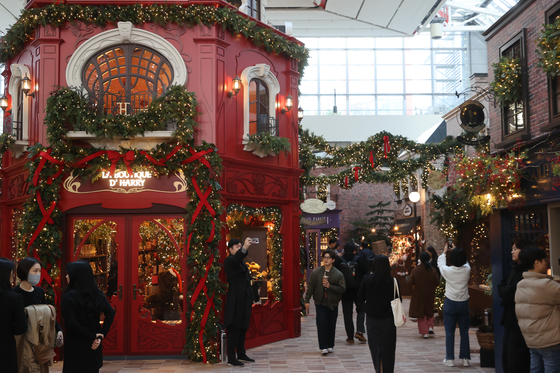 Visitors look around La Boutique d'Harry, a Christmas-themed village at The Hyundai Seoul in Yeongdeungpo District, western Seoul. [YONHAP]