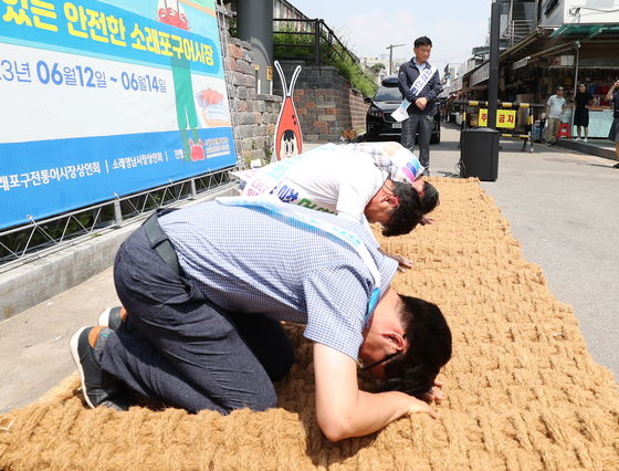 Soraepogu fish market merchants apologizing to the public for questionable business practices including selling crabs that are missing more than a single leg in front of the market on June 14. [YONHAP] 