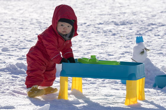 A child stands on the snowy ground of Snowyland at Vivladi Park in Hongcheon County, Gangwon. [VIVALDI PARK]