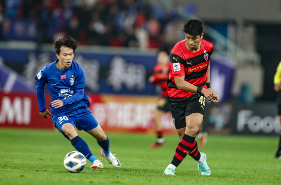 The Pohang Steelers' Ha Chang-rae, right, in action during an AFC Champions League match against Wuhan Three Towns at Wuhan Sports Center Stadium in Wuhan, China on Wednesday. [AFC]