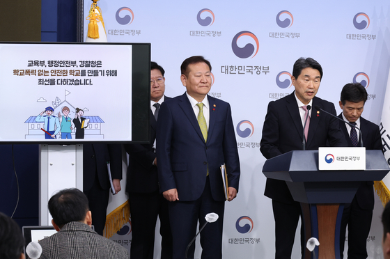Education Minister Lee Ju-ho, center, and Interior and Safety Minister Lee Sang-min announces measure to improve the burden on teachers investigating school violence at the government complex in Seoul on Thursday. [YONHAP]