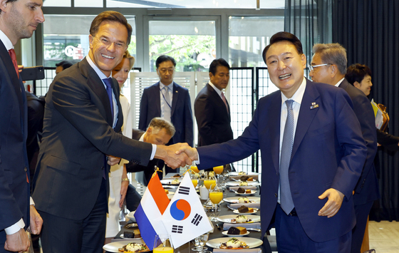 Korean President Yoon Suk Yeol, right, shakes hands with Dutch Prime Minister Mark Rutte during a lunch meeting in Vilnius, Lithuania, on July 11, on the sidelines of a NATO summit. [JOINT PRESS CORPS]