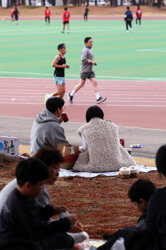 People take advantage of the spring-like weather with lighter clothing and outdoor picnics at Chonnam National University in Buk District, Gwangju, on Sunday when the daily highest temperature hit 20.3 degrees Celsius (68.54 degrees Fahrenheit). [YONHAP]