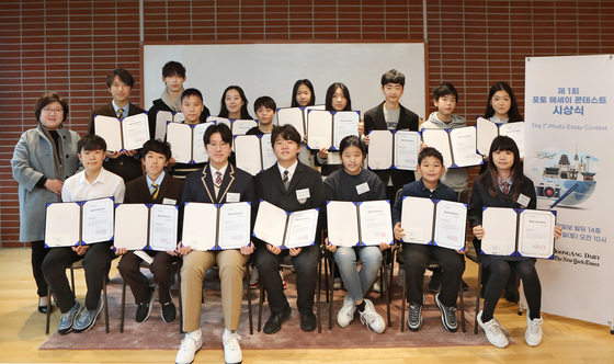 Choi Ji-young, executive editor of the Korea JoongAng Daily, far left, and winners of the Korea JoongAng Daily's first Photo Essay Contest pose for a photo holding their awards at the Korea JoongAng Daily office in Mapo District, western Seoul, on Saturday. [PARK SANG-MOON]