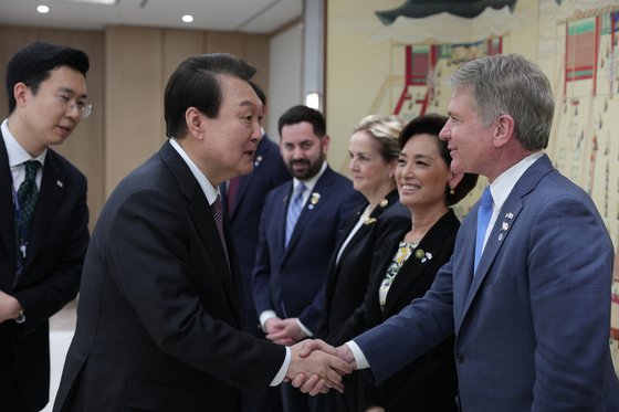 President Yoon Suk Yeol, left, shakes hands with U.S. House Rep. Michael McCaul, chair of the Foreign Affairs Committee, at the presidential office in Seoul on April 5. Joining the delegational visit were representatives Young Kim, second from right, and Mike Lawler, fourth from right. [JOING PRESS CORPS]
