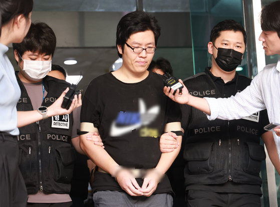 Choi Yoon-jong is being escorted by the Gwanak police on Aug. 25 for questioning by prosecutors regarding his killing of a woman he followed into a park in Sillim-dong, Gwanak District, southern Seoul. [YONHAP]