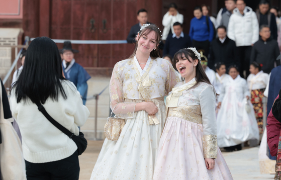 Foreigners in hanbok, or Korean traditional clothing, take a photo at Gyeongbok Palace in Jongno DIstrict, central Seoul, on Friday. [YONHAP] 