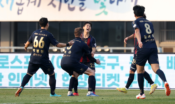 Suwon FC players celebrate Lee Gwang-hyeok’s goal during a K League promotion-relegation playoff match against Busan IPark at Suwon Sports Complex in Suwon, Gyeonggi on Saturday. [NEWS1]