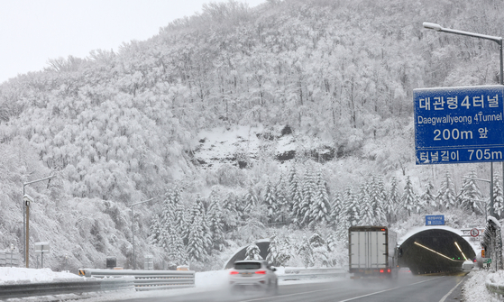 Cars pass along on the Daegwallyeong part of the Yeongdong Expressway in Gangwon on Tuesday morning. The Daegwallyeong region saw heavy snowfall from Monday. [YONHAP]