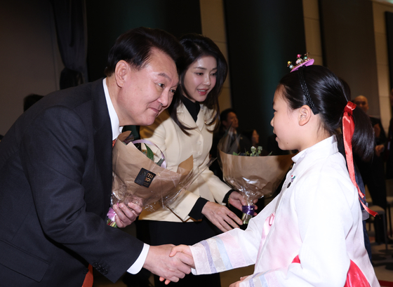 Korean President Yoon Suk Yeol, left and first lady Kim Keon Hee are greeted by children in hanbok during a dinner meeting with Korean nationals at a hotel in Amsterdam Monday. [JOINT PRESS CORPS]