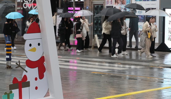 Residents and tourists in Haeundae District in Busan are with their umbrellas amid the rainfall in Busan on Monday. [SONG BONG-GEUN, JOONGANG PHOTO]