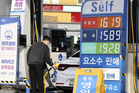 A driver refuels his car at a gas station in Seoul on Sunday. Finance Minister Choo Kyung-ho said on Tuesday that the tax cut on fuel consumption, which expires this month, will be extended for another two months. [YONHAP]