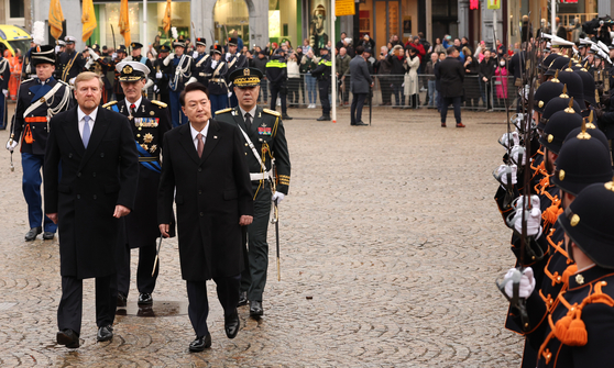 President Yoon Suk Yeol, right, and Dutch King Willem-Alexander, left, take part in a welcome ceremony at Dam Square, Amsterdam, during the Korean leader’s five-day state visit to the Netherlands on Tuesday. [JOINT PRESS CORPS]