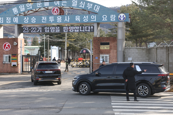 BTS's Jimin and Jungkook pass through the gate of a military boot camp in Yeoncheon County, Gyeonggi, where they will receive basic training in black SUVs on Tuesday.[YONHAP]