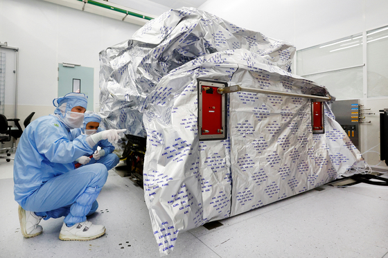 Assembly engineers work on a TWINSCAN DUV lithography system at ASML in Veldhoven, Netherlands June 16, 2023. [REUTERS]