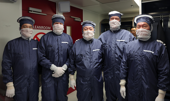 President Yoon Suk Yeol, center, joined by executives of Korea's top chipmakers, visits Dutch semiconductor equipment maker ASML's cleanroom at its global headquarters in Veldhoven in the Netherlands on Tuesday. From left, Samsung Electronics Chairman Lee Jae-yong, Dutch King Willem-Alexander, Yoon, ASML Chief Executive Peter Wennink and SK Group Chairman Chey Tae-won. [JOINT PRESS CORPS]