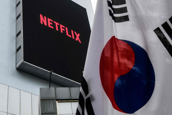 The Netflix logo displayed on a large digital display behind a Korean flag in Seoul on Oct. 7, 2021. [AFP/YONHAP]